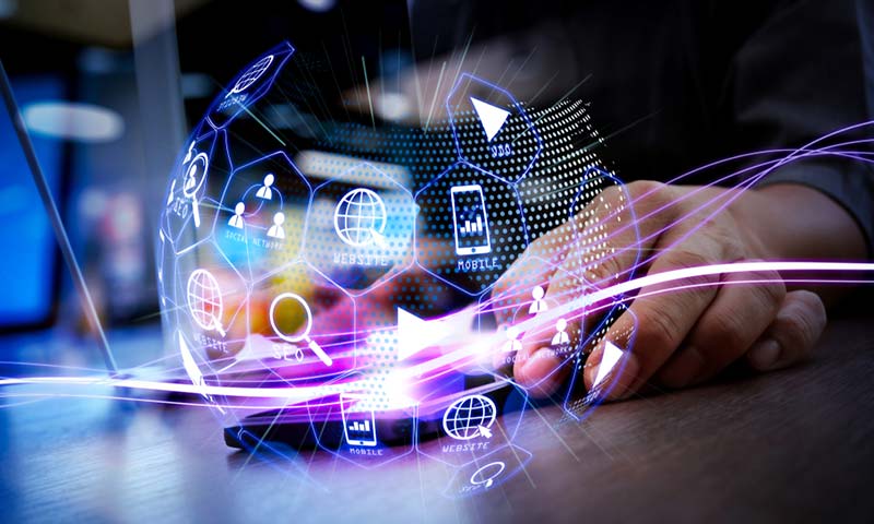 marketing-globe Someone using a smart phone with waves of blue light coming from it and a globe shape that is glowing with various marketing icons on it.