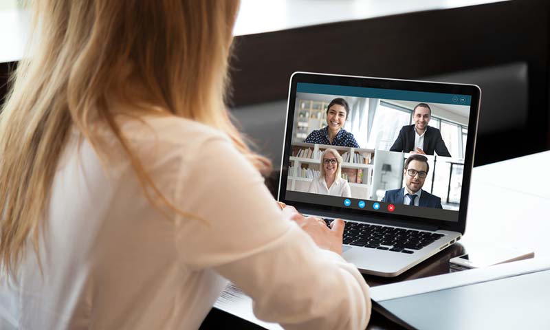 communicate A woman having a video call with other business people.
