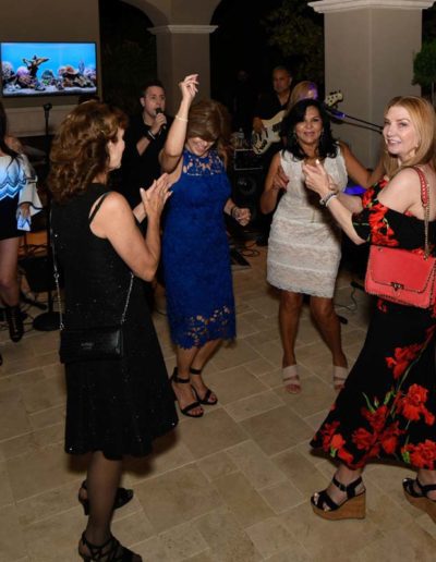 A group of women dancing outside at a party