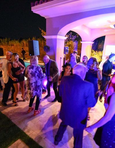 People dancing at night outside at pool party