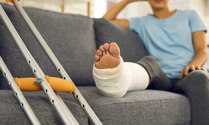 Person on the couch with leg in a cast
