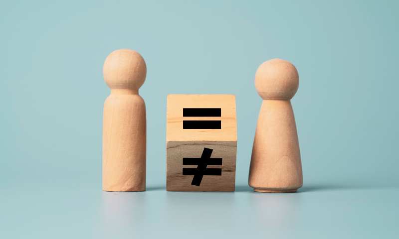 A wooden cube being flipped to an equal sign with a wooden game piece figure on each side of the cube.