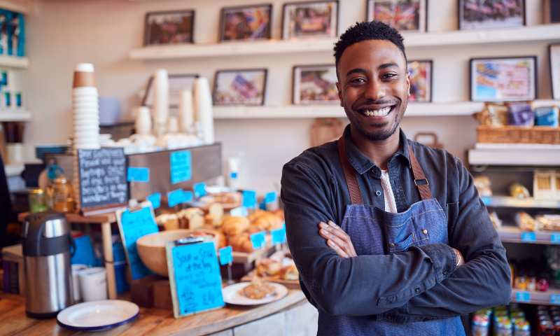 Smiling young man in his coffee shop