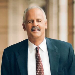 Stedman Graham, a man with white hair wearing a blue suit and tie