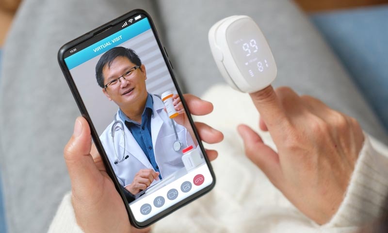 Doctor helping a patient on a smartphone video call.