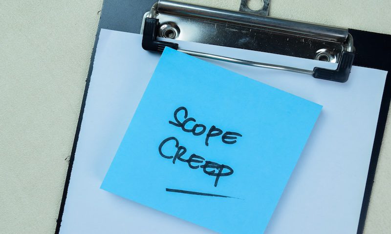 Concept of Scope Creep write on sticky notes isolated on Wooden Table.